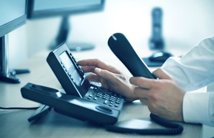 Hands using an office telephone, from the original HMC website